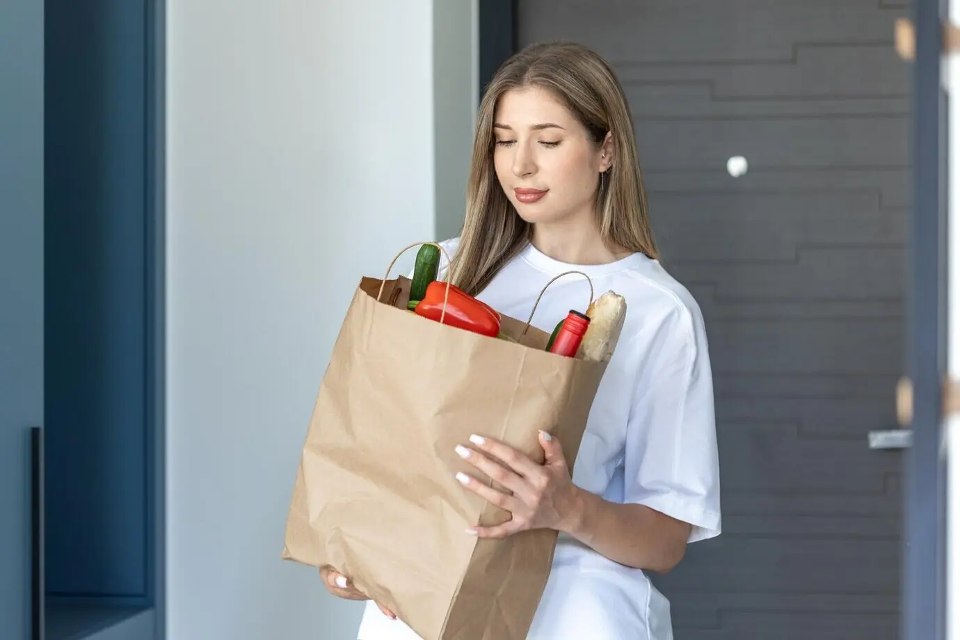 Frau mit Einkaufstüte, Lebensmittellieferung nach Hause, frisches Gemüse und Brot.